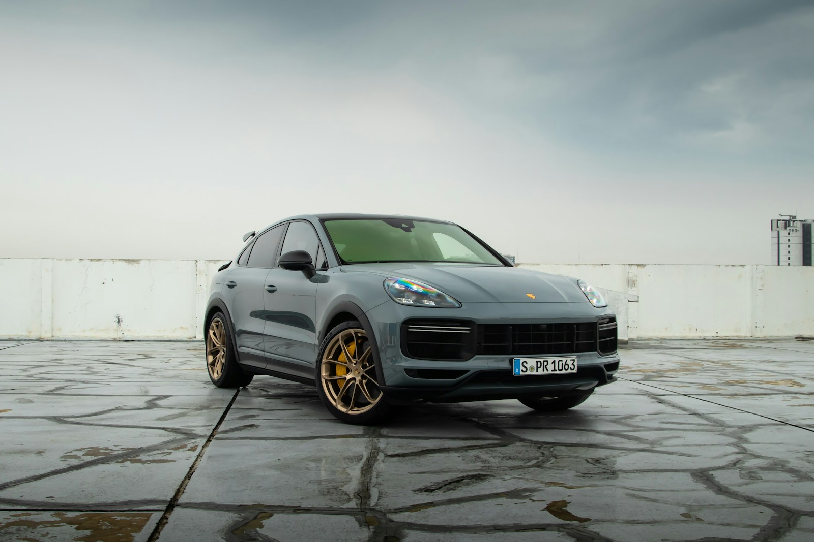 a grey porsche cayen is parked in a parking lot